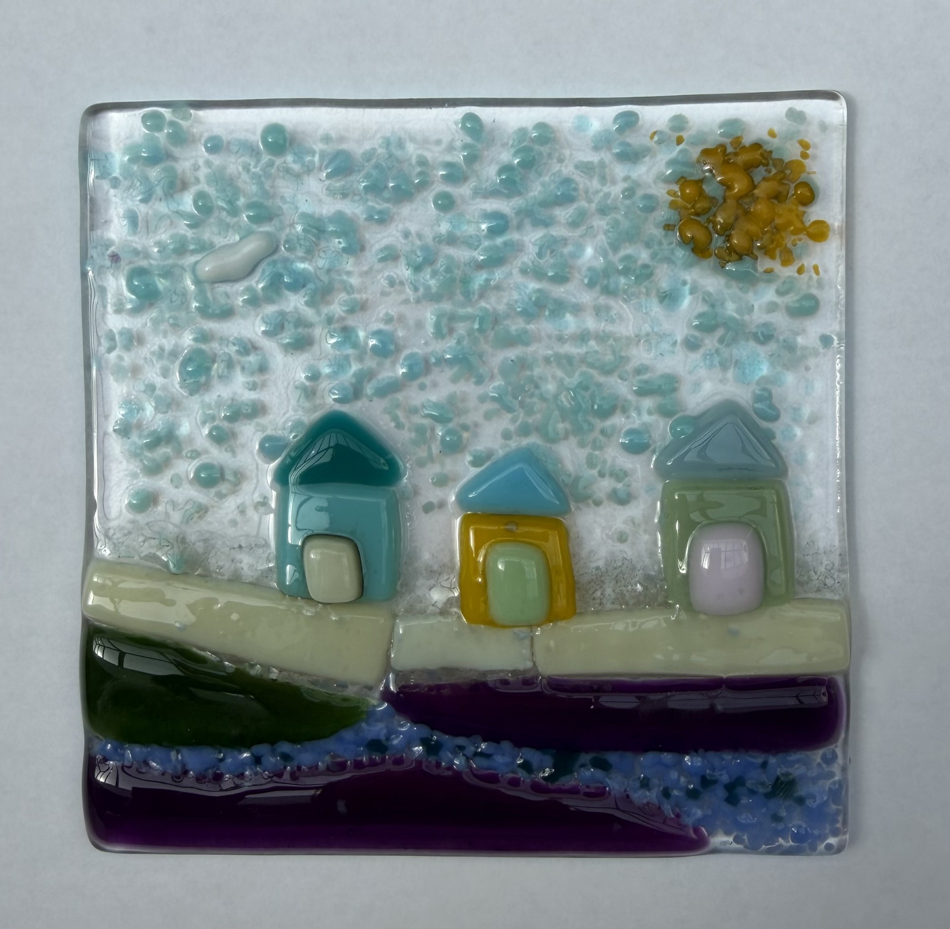 Small fused glass panel showing beach huts, sea and sun